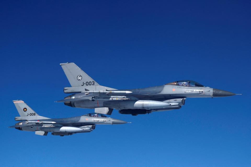 Netherlands' Air Force F-16 fighter jets fly alongside an aircraft simulating aerial interceptions during a media day illustrating how NATO Air Policing safeguards the Allies' airspace in the northern and northeastern region of the Alliance, July 4, 2023.