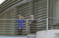 German Chancellor Angela Merkel and Britain's Prime Minister Boris Johnson talk as they stand on a balcony prior to a dinner as part of a meeting at the Chancellery in Berlin, Germany, Wednesday, Aug. 21, 2019. (AP Photo/Michael Sohn)