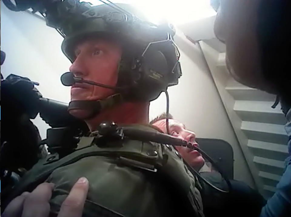 In the footage supplied by police, officers are seen looking behind curtains as well as one who grabbed an assault-style rifle from the ledge of a broken window. Source: Las Vegas Metropolitan Police Department via AP