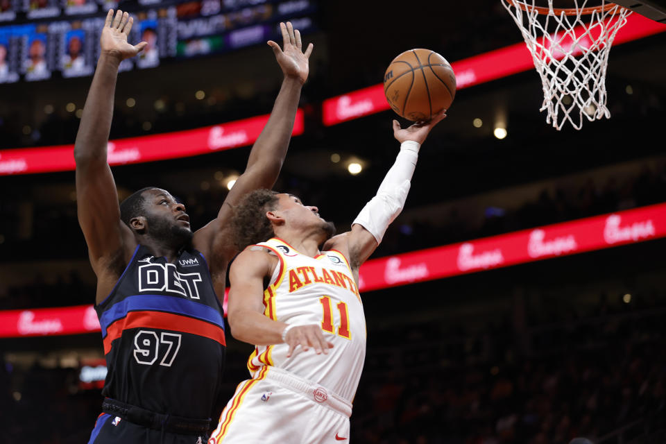 Atlanta Hawks guard Trae Young, right, shoots against Detroit Pistons forward Eugene Omoruyi, left, during the first half of an NBA basketball game Tuesday, March 21, 2023, in Atlanta. (AP Photo/Alex Slitz)