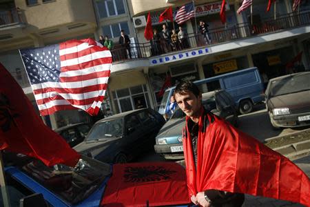 An ethnic Albanian man is seen wrapped in the Albanian flag in celebration for the province's upcoming independence, in the village of Suva Reka in Kosovo, in this February 15, 2008 file photo. REUTERS/Damir Sagolj/Files