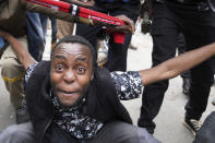 A protester gestures as Kenya police fire teargas canisters during a protest in downtown Nairobi, Kenya Thursday, June 27, 2024. Thousands of protesters stormed and burned a section of Kenya's parliament Tuesday to protest tax proposals. Police responded with gunfire and several protesters were killed. (AP Photo/Brian Inganga)