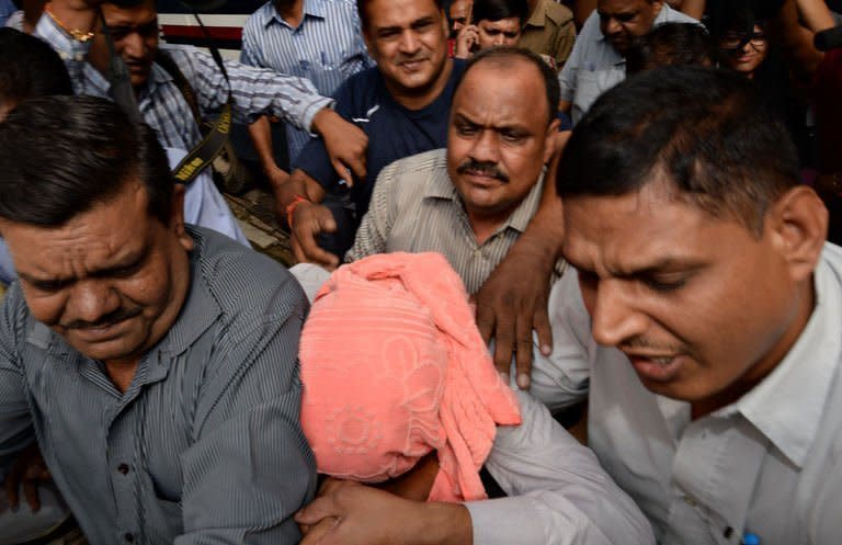 Indian policemen escort the juvenile (in pink hood), accused in the December 2012 gang-rape of a student, to a court in New Delhi on Saturday. An Indian court found a teenager guilty on Saturday over the fatal gang-rape of a student in New Delhi, a crime that sparked angry protests, an official said