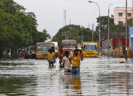 People wade through a flooded road in Chennai, India, December 5, 2015. REUTERS/Anindito Mukherjee