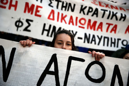 A girl holds a banner during a rally marking the anniversary of the 2008 police shooting of 15-year-old student Alexandros Grigoropoulos, in Athens, Greece, December 6, 2017. REUTERS/Costas Baltas