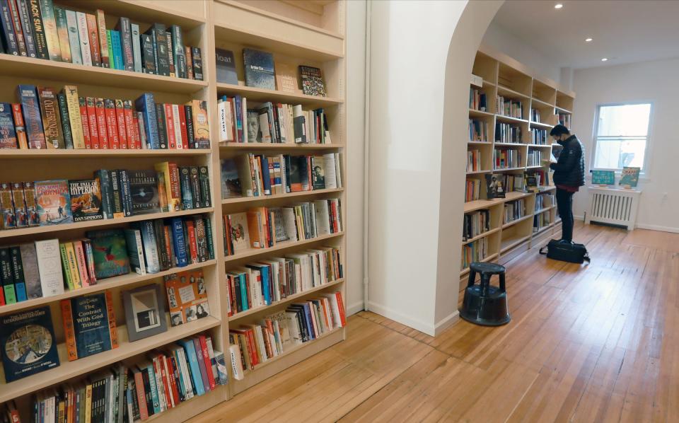 A customer looks over the selection of books at Transom Books in Tarrytown on Wednesday, November 24, 2021.