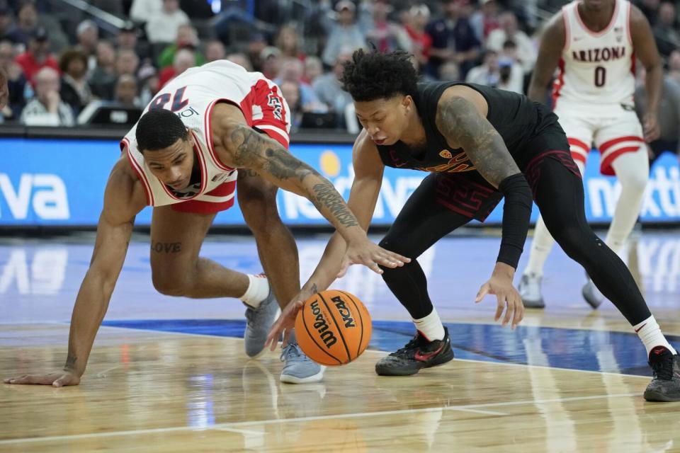 Arizona forward Keshad Johnson, left, and USC guard Boogie Ellis scramble for a loose ball in the first half Thursday.