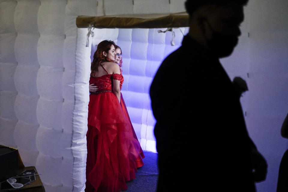 Julie Lattang, 18, and Brianna Cazadillas, 17, have their picture taken in a photo booth while attending prom at the Grace Gardens Event Center in El Paso, Texas on Friday, May 7, 2021. Around 2,000 attended the outdoor event at the private venue after local school districts announced they would not host proms this year. Tickets cost $45. (AP Photo/Paul Ratje)