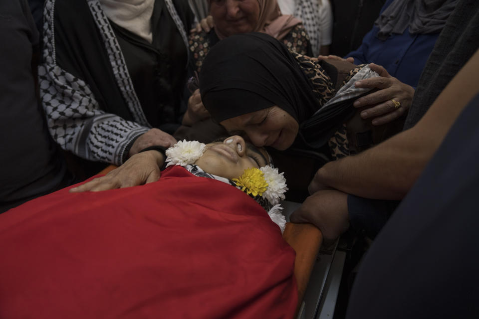 An'am al-Soos, grandmother of Sohaib al-Soos, 15, takes the last look at his body during his funeral in the West Bank city of Ramallah, Saturday, Oct. 21, 2023. Al-Soos was killed during an Israeli army raid in the town of Betunia last Friday, the Palestinian ministry of health said. (AP Photo/Nasser Nasser)