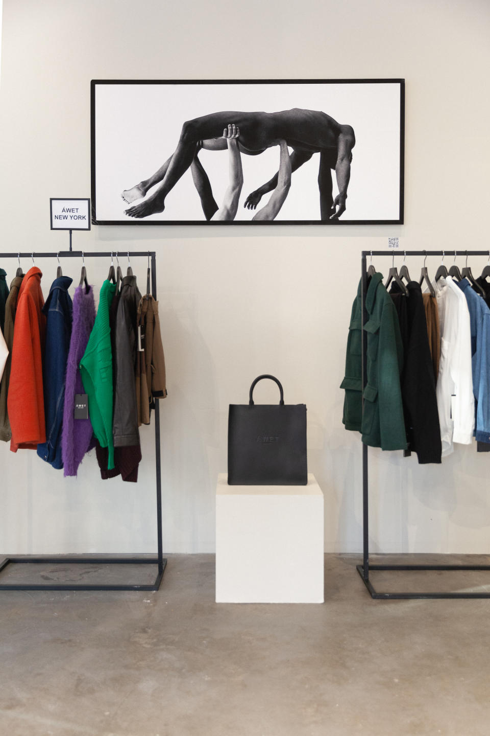 Livewear NYC where BIPOC designers get center stage. Here an artistic image of a Black model uplifted and clothing racks. 