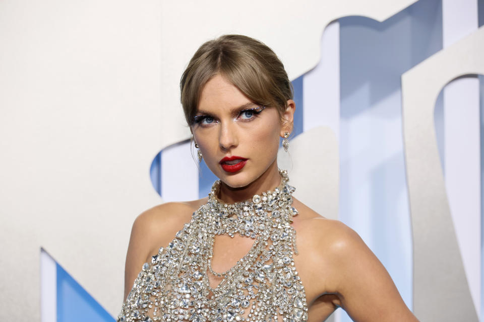 Taylor Swift wearing a bejeweled halter dress at a red carpet event