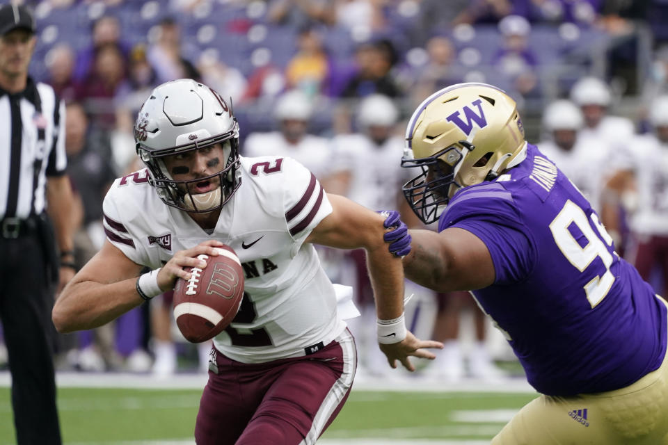 Montana quarterback Cam Humphrey (2) scrambles away from Washington's Sam Taimani in the first half of an NCAA college football game Saturday, Sept. 4, 2021, in Seattle. (AP Photo/Elaine Thompson)