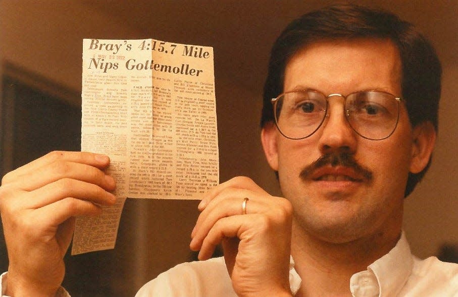 Jim Bray holds a newspaper clip on May 16, 1989 that describes his state record mile run in 1972.