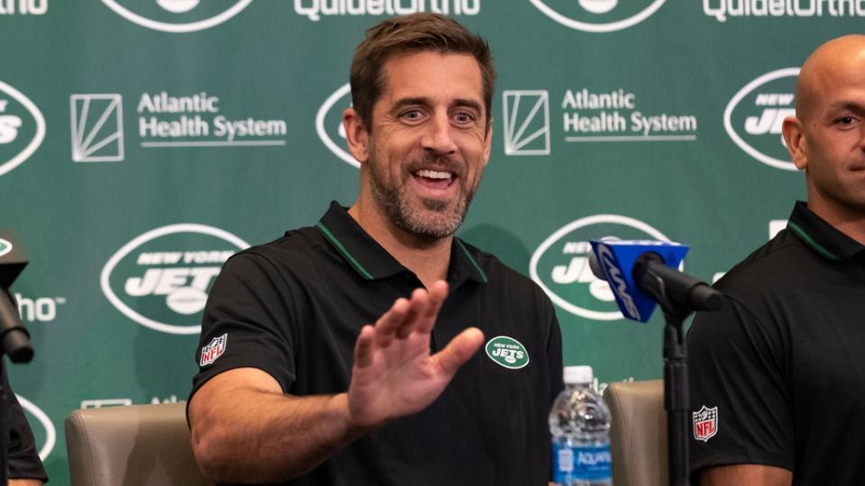 Aaron Rodgers waves to someone during his introductory news conference with the Jets.