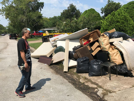 Jose Luis Perales piles damaged furniture, carpets and articles of clothing on his curb cleaning up his home from the flooding caused by Hurricane Harvey, in Houston, Texas, U.S., September 1, 2017. REUTERS/Mica Rosenberg