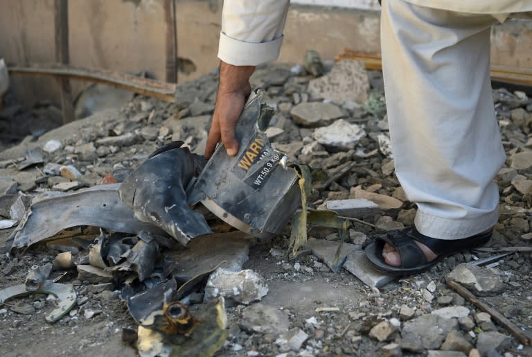 An Afghan resident collects pieces of shrapnels in a damage courtyard house following a hit by a NATO airstrike at a residential house in Kabul on September 28, 2017 Haji Rabbani was preparing for afternoon prayers when he saw the US helicopters hovering above his mud-brick house in a residential area of Kabul. Moments later bombs started raining down