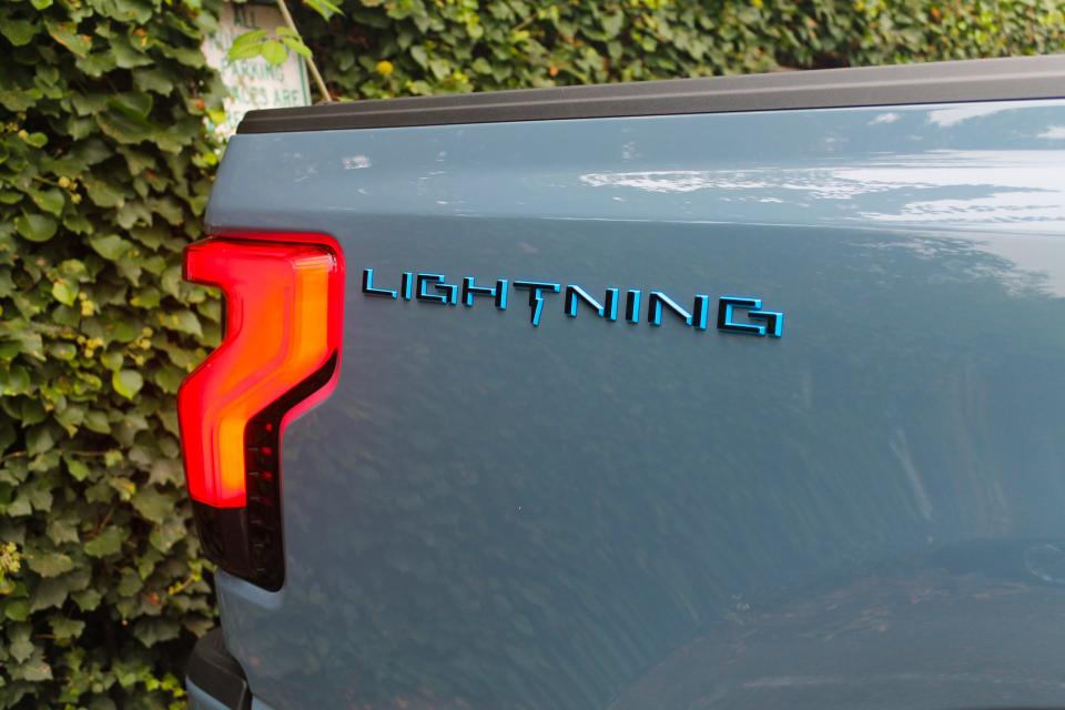 The "LIGHTNING" logo and a red taillight seen on the 2023 Ford F-150 Lightning Platinum.