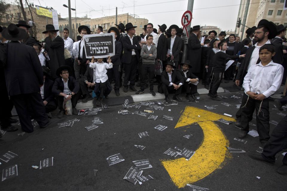 Ultra-Orthodox Jews rally in a massive show of force against plans to force them to serve in the Israeli military, blocking roads and paralyzing the city of Jerusalem, Sunday, March 2, 2014. The widespread opposition to the compulsory draft poses a challenge to the country, which is grappling with a cultural war over the place of the ultra-Orthodox in Israeli society. With secular Jews required to serve, the issue is one of the most sensitive flashpoints between Israel's secular majority and its devout minority. Hebrew sign reads: "The holy bible will win." (AP Photo/Sebastian Scheiner)