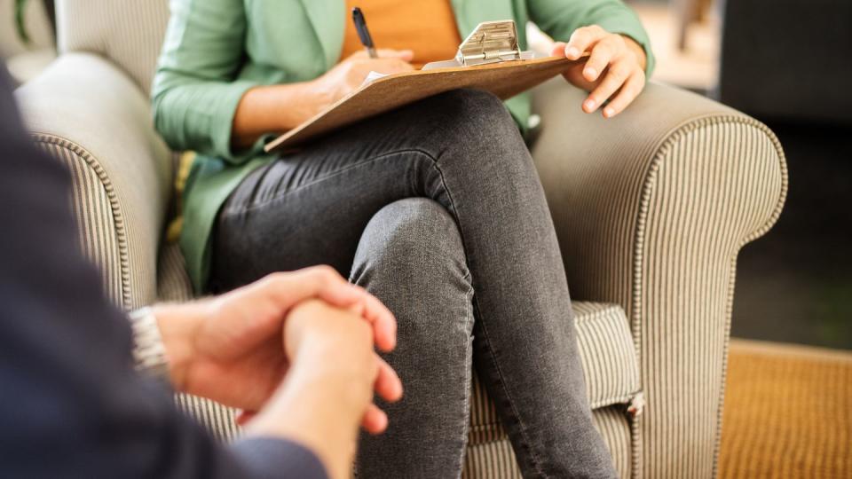 mental health professional taking notes during a counseling session