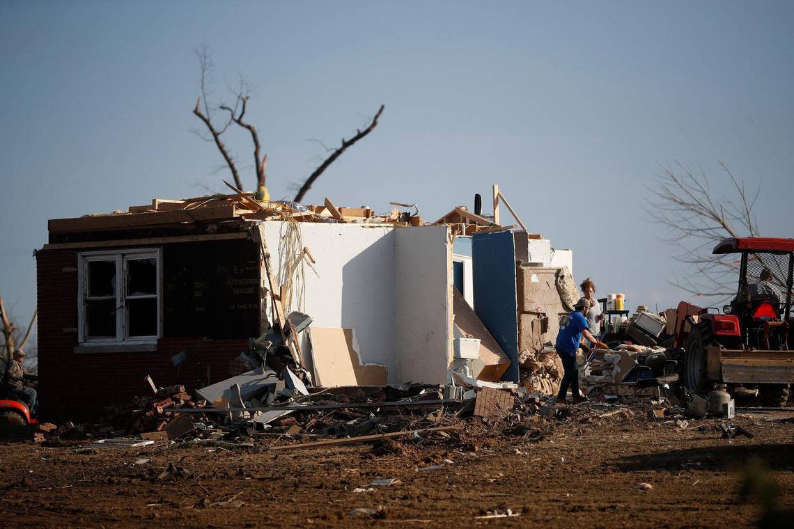 People work near a tornado damaged home in Bremen, Ky., Tuesday, Dec. 14, 2021.
