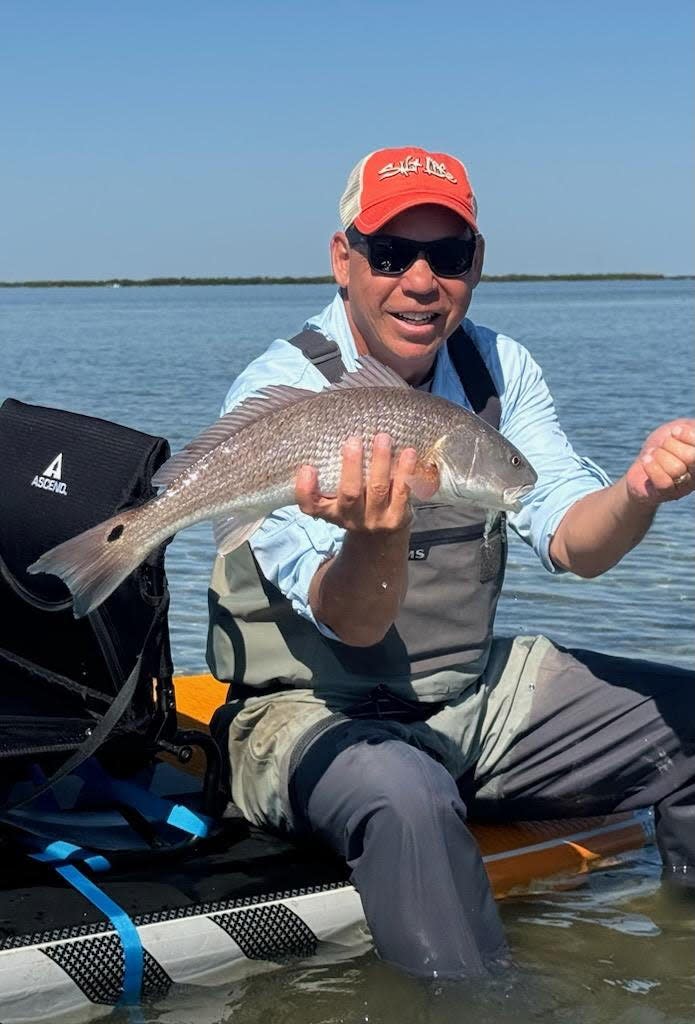 Tom Norton, visiting from Pittsburgh, slipped into his waders and into the Canaveral Seashore waters to bring in this lovely red on a fly. He was fishing with Geno Giza.