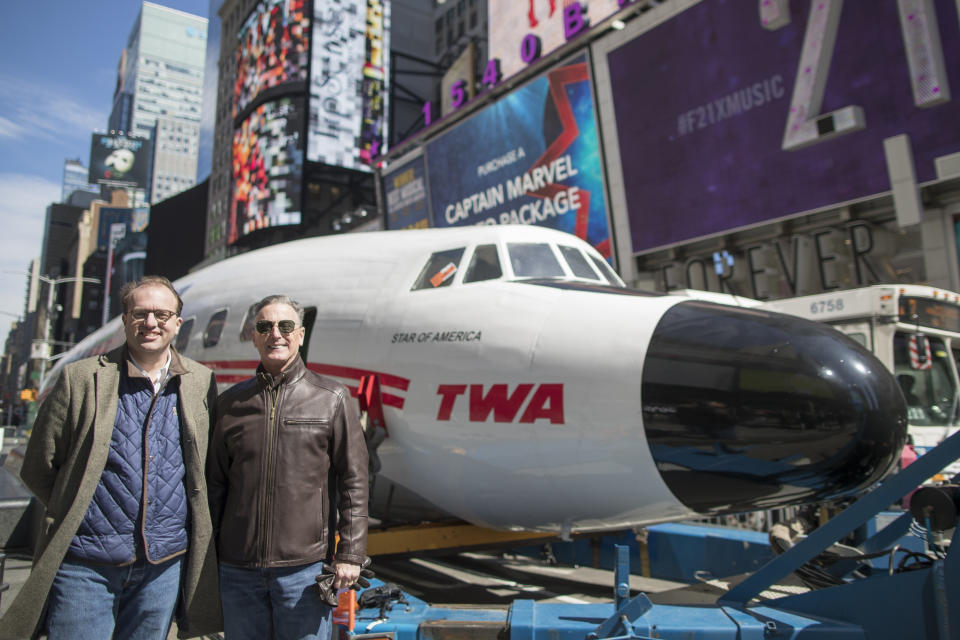 CEO and Managing Partner of MCR Tyler Morse, left, and Hotel Trades Council President Peter Ward pose for a photo next to a Lockheed Constellation L-1649A Starliner, known as the "Connie, is parked in New York's Times Square during a promotional event, Saturday, March 23, 2019, in New York. The vintage commercial airplane will serve as the cocktail lounge outside the TWA Hotel at JFK airport, a hotel that promises to bring back "the magic of the Jet Age." (AP Photo/Mary Altaffer)