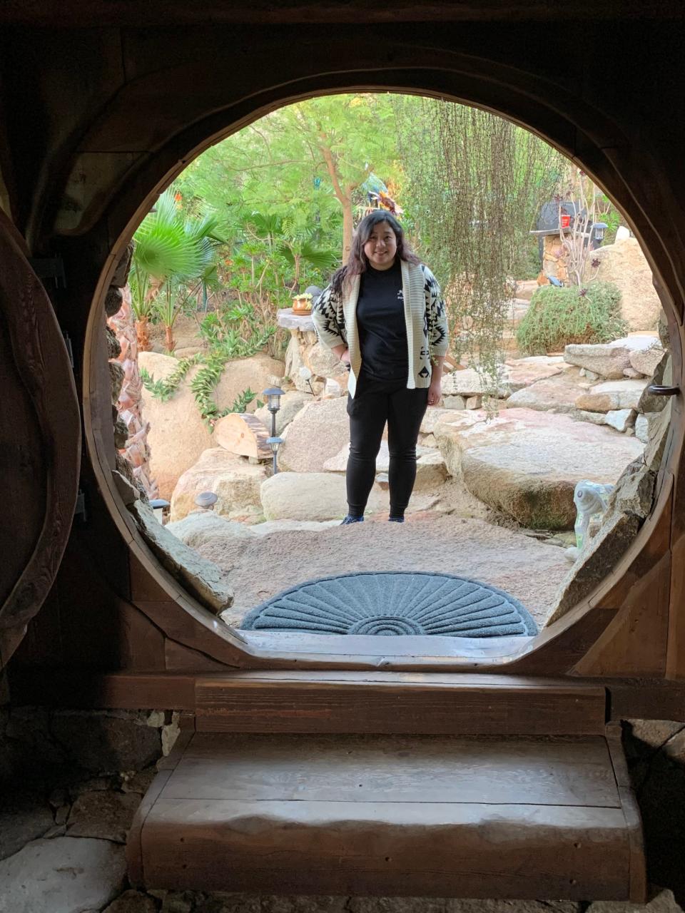 A woman as seen through a circular doorway.