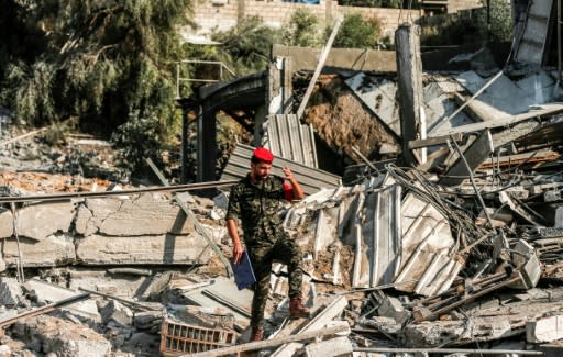 A member of the Hamas military police walks through rubble at a site hit by Israeli air strikes in Gaza City on August 9, 2018
