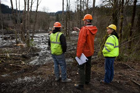 Snohomish County officials evaluate the scene left by a mudslide in Oso, Washington, April 3, 2014. REUTERS/Max Whittaker