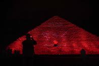 The Ministry of Antiquities lights up the Giza pyramids in an expression of support for health workers battling the coronavirus, in Giza, Egypt, Monday, March 30, 2020. The Egyptian government extended the closure of the country's famed museums and archaeological sites, including the Pyramids and the Sphinx at Giza, until at least April 15. (AP Photo/Nariman El-Mofty)