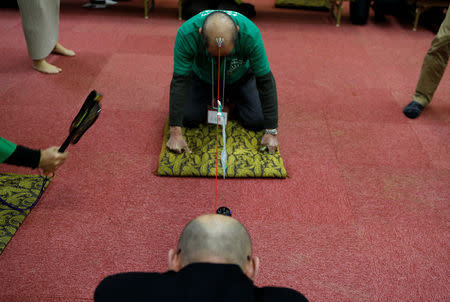 Members of the Bald Men Club, take part in a unique game of tug-of-war by attaching suction pads onto their heads, at a hot spring facility in Tsuruta town, Aomori prefecture, Japan, February 22, 2017. REUTERS/Megumi Lim