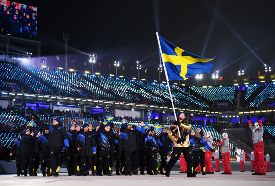 <p>Flag bearer of Sweden Niklas Edin and teammates enter the stadium wearing chic knit hats and pants with a minimalistic yellow block motif to symbolize their flag, accompanied by navy-and-black puffer jackets. Leave it to the Swedes to stay stylish no matter the event. (Photo: Matthias Hangst/Getty Images) </p>