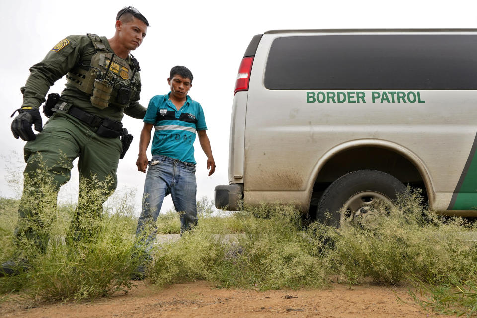 A migrant is led to transport after being apprehended by U.S. Border Patrol agents at the base of the Baboquivari Mountains, Thursday, Sept. 8, 2022, near Sasabe, Ariz. The desert region located in the Tucson sector just north of Mexico is one of the deadliest stretches along the international border with rugged desert mountains, uneven topography, washes and triple-digit temperatures in the summer months. Border Patrol agents performed 3,000 rescues in the sector in the past 12 months. (AP Photo/Matt York)