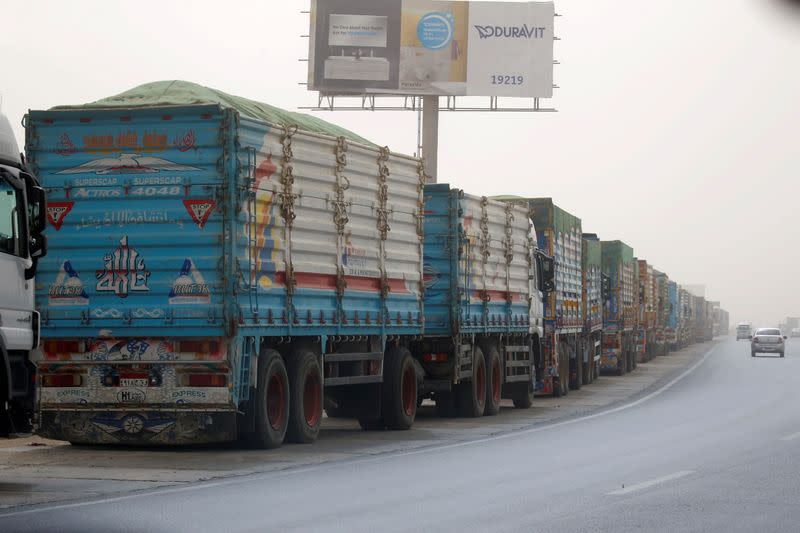 Trucks wait to pass through the main gate of the El Ain El Sokhna port to Suez Canal on a dusty weather