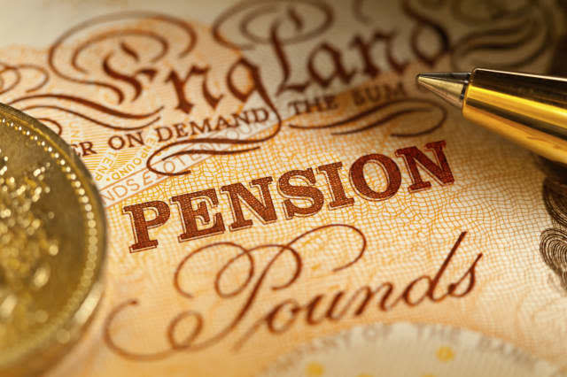 Sterling Pension Savings in the UK. A Ten Pound sterling bank note with a pound coin and a ballpoint pen, with focus on the word