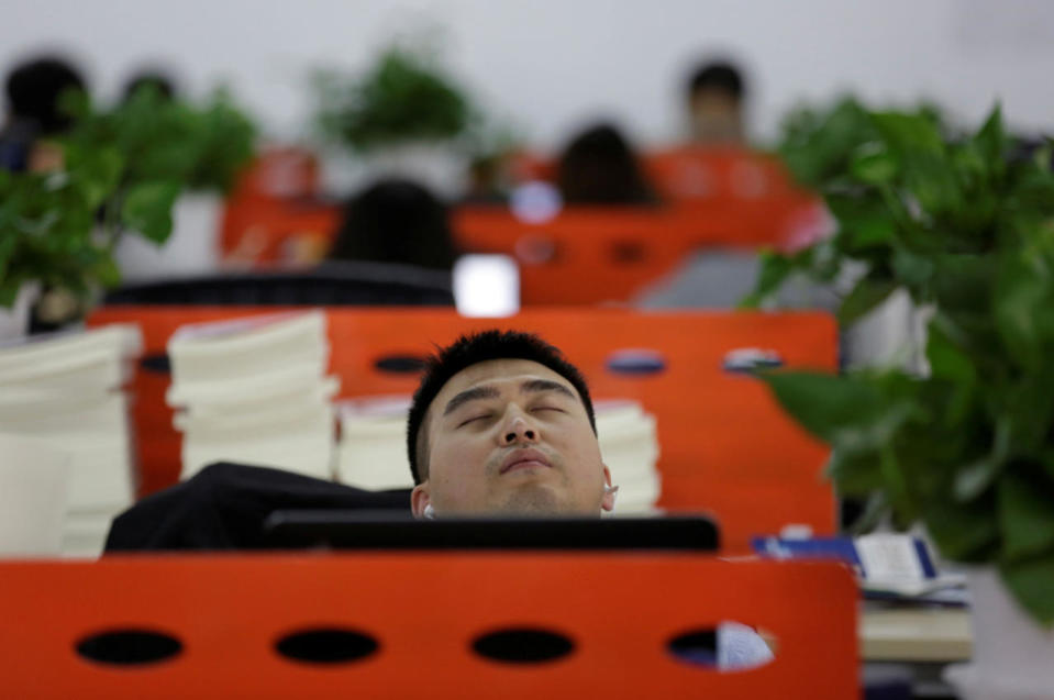 Cui Meng, a co-founder of Goopal Group, takes a nap in his seat after lunch, in Beijing on April 21, 2016. (Jason Lee/Reuters)