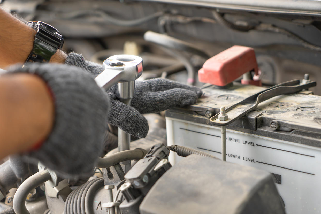 Mechanic, technician man check the car engine in garage. Car service, repair, fixing, checking maintenance working with socket wrench at workshop. Inspection vehicle concept Car mechanic using spanner examining automobile at repair service station.