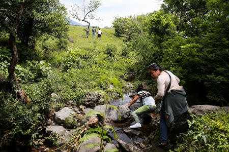 Locals avoid a police checkpoint to access an area affected by the eruption of the Fuego volcano, to search for their missing relatives in San Miguel, Escuintla, Guatemala, June 8, 2018. REUTERS/Luis Echeverria