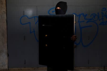 A demonstrator holding a rudimentary shield poses for a picture before a rally against Venezuelan President Nicolas Maduro's government in Caracas, Venezuela, June 17, 2017. He said: "I protest because this country is in misery and we want a better future for our children." REUTERS/Carlos Garcia Rawlins