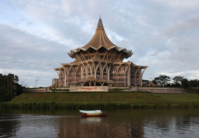 A boat passes by the Sarawak State Legislative Assembly in Kuching, the capital city of Malaysia's Sarawak state, on February 7, 2013. A state minister said Sarawak gov't will not push ahead with building 12 controversial dams amid anger among local tribes and environmentalists over the plans