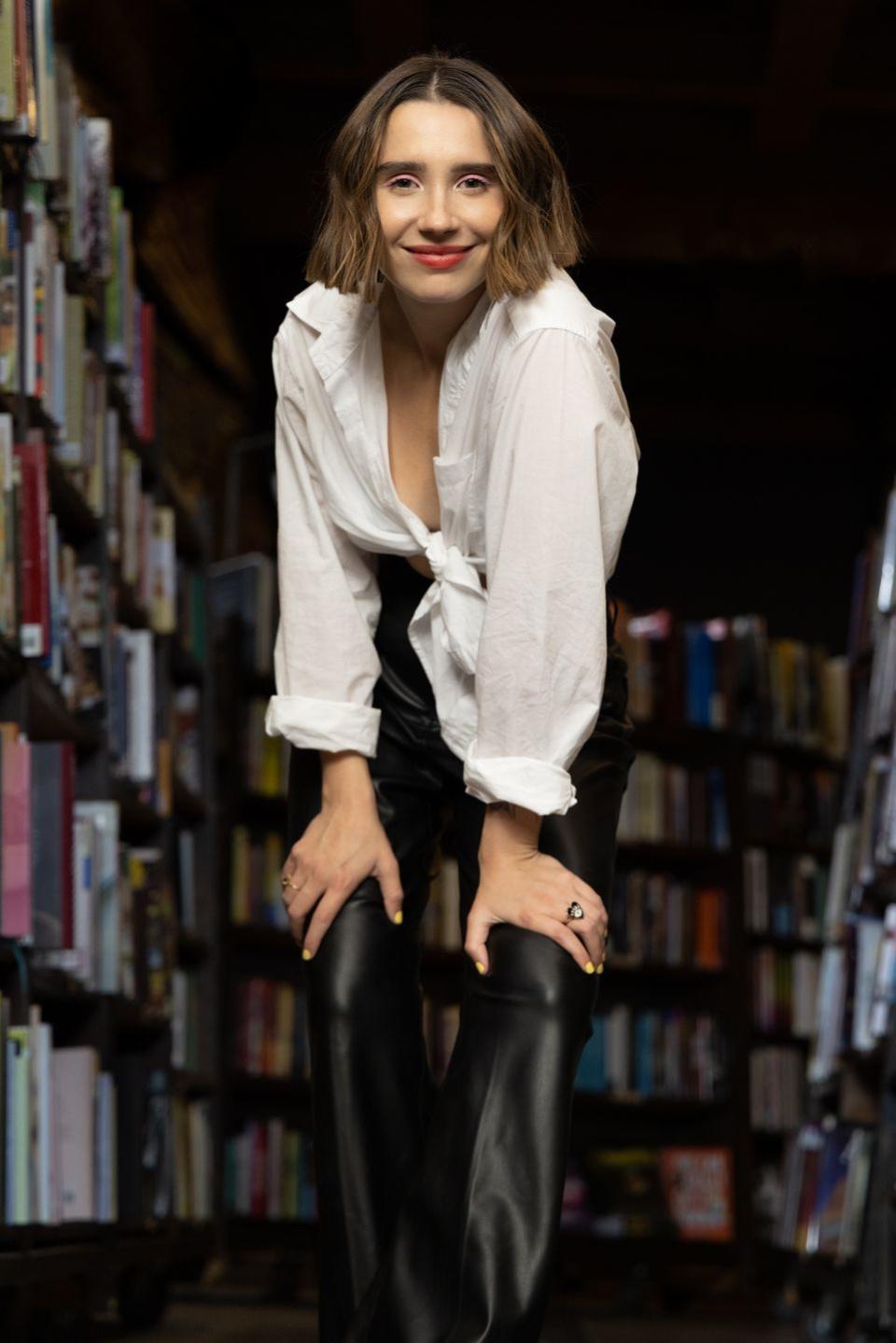 amanda montell standing in front of a bookshelf