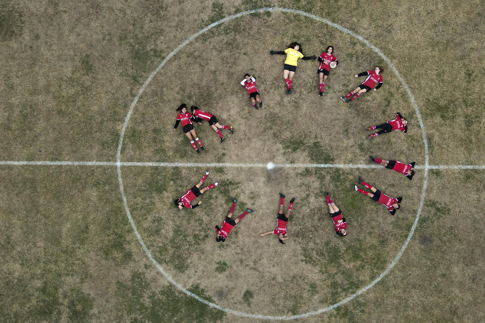 Candelaria Cabrera (arriba a la derecha) sostiene un balón, al posar junto a sus compañeras antes de un partido en Arequito, Argentina, el 19 de junio de 2023. Desde 2019, la liga regional ha ofrecido partidos para futbolistas en las categorías sub12 y sub14 (AP Foto/Natacha Pisarenko).