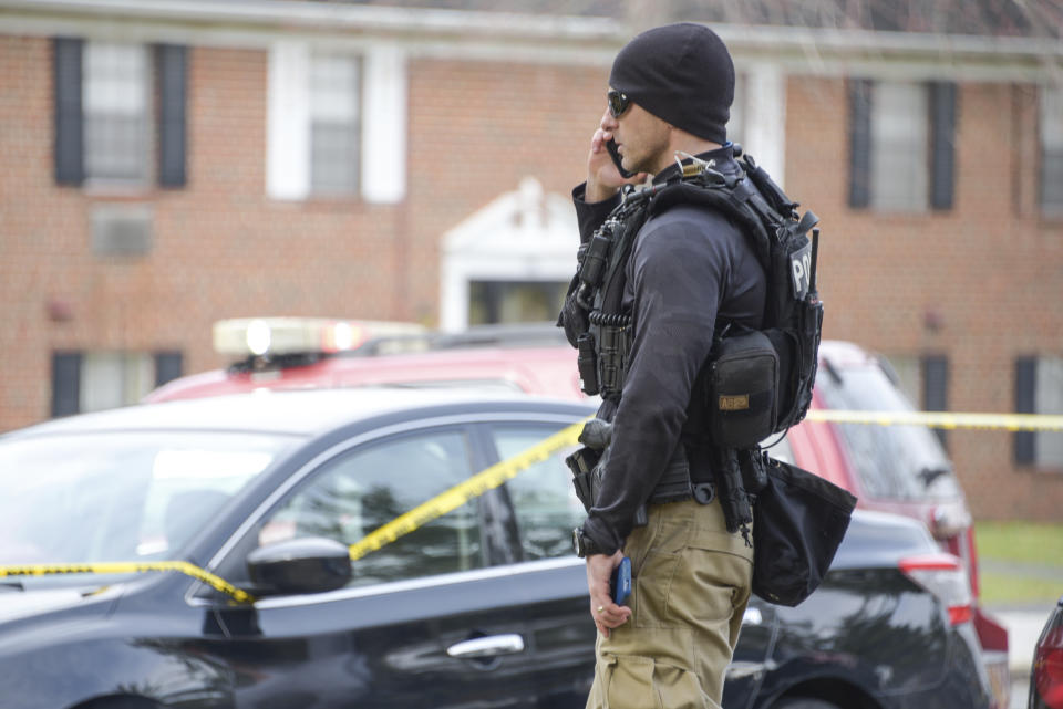 Law enforcement personnel work at the scene of a shooting, Wednesday, Feb. 12, 2020, in Baltimore. Two law enforcement officers with a fugitive task force were injured and a suspect died in the shooting, the U.S. Marshals Service said. (Ulysses Muñoz/The Baltimore Sun via AP)