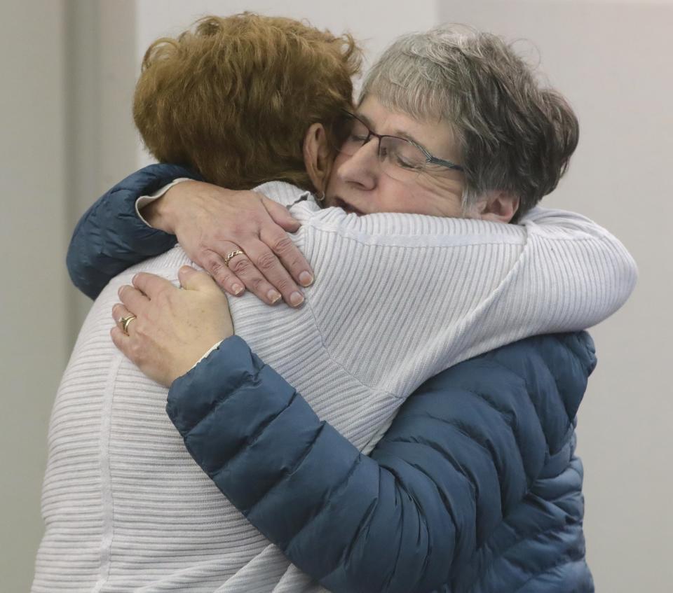 Former Macy's employees Jo Lofland, left, and Janet Marshall embrace Wednesday after a gathering in Stow City Council chambers to talk about their years of employment at the department store.