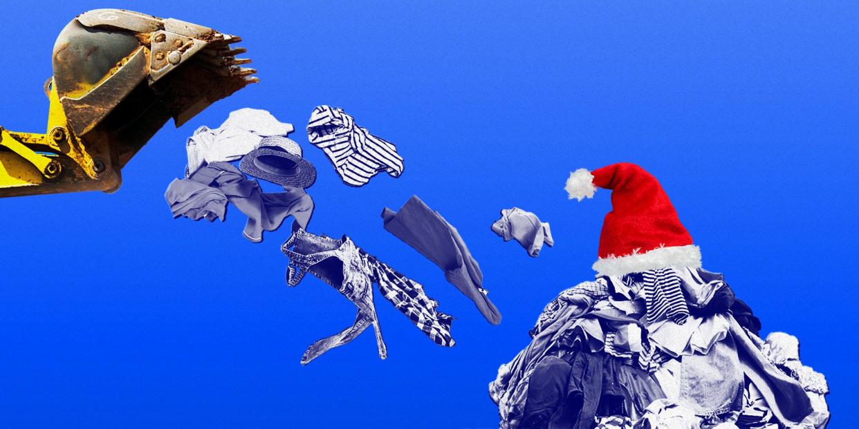 An excavator arm dropping clothes onto a pile of clothes with a Santa hat on top