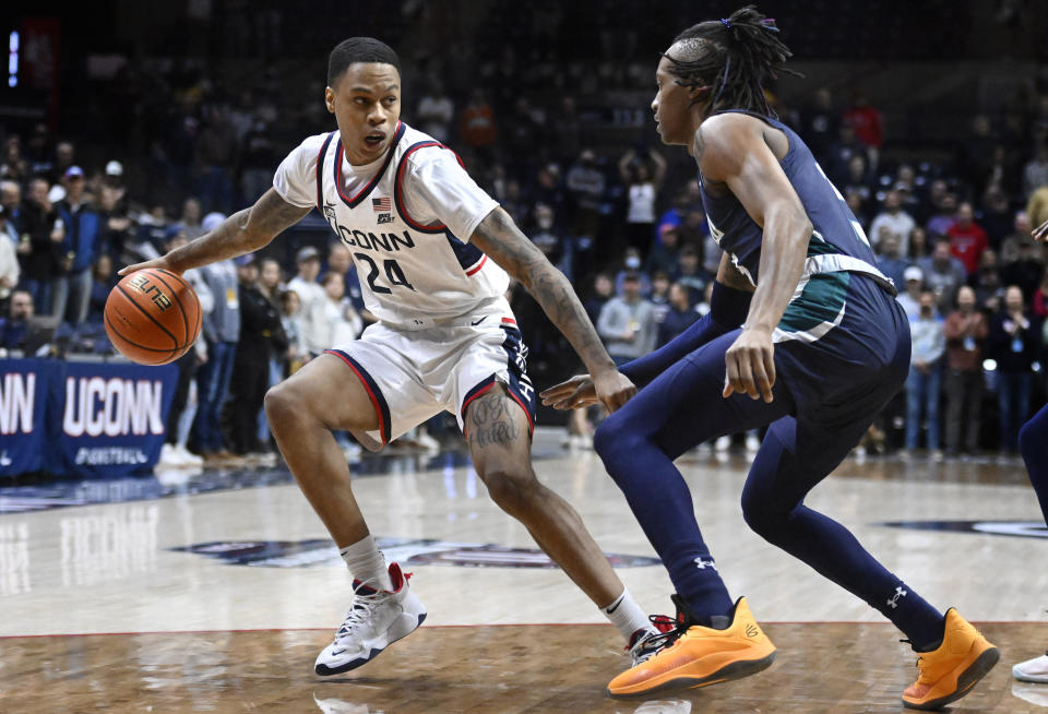 Connecticut's Jordan Hawkins, left, is guarded by UNC Wilmington forward Trazarien White during the first half of an NCAA college basketball game Friday, Nov. 18, 2022, in Storrs, Conn. (AP Photo/Jessica Hill)