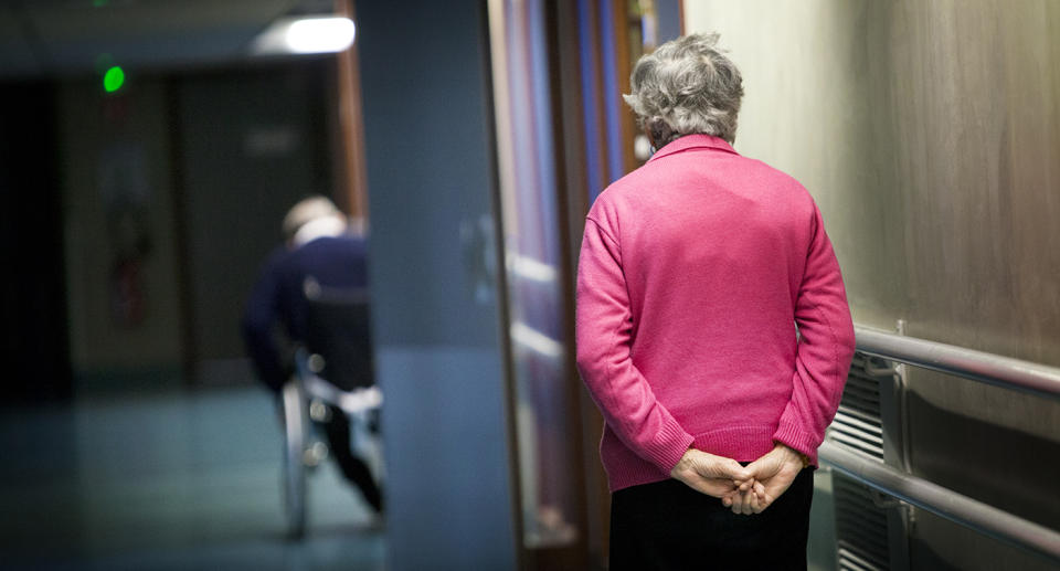 The hallway of an aged care facility with two patients in the halls.