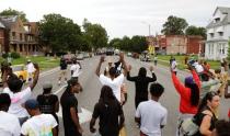 Protestors hold their hands up as police approach them on Page Ave. after a shooting incident in St. Louis, Missouri August 19, 2015. REUTERS/Lawrence Bryant