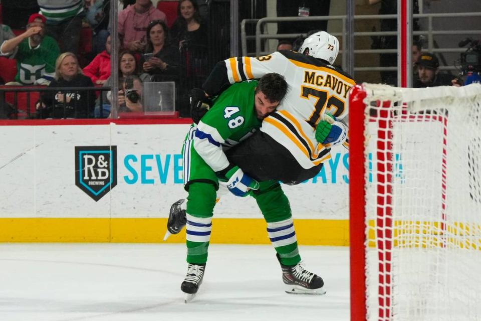 Carolina Hurricanes left wing Jordan Martinook (48) and Boston Bruins defenseman Charlie McAvoy (73) fight during the first period at PNC Arena.