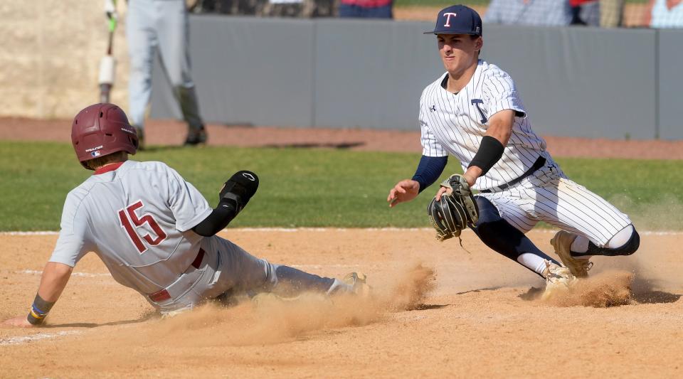 Trinity's Brady Rascoll (1) tags out UMS Wright's Tyler Waters (15) at home during their game on the Trinity campus in Montgomery, Ala, on Thursday May 4, 2023. 